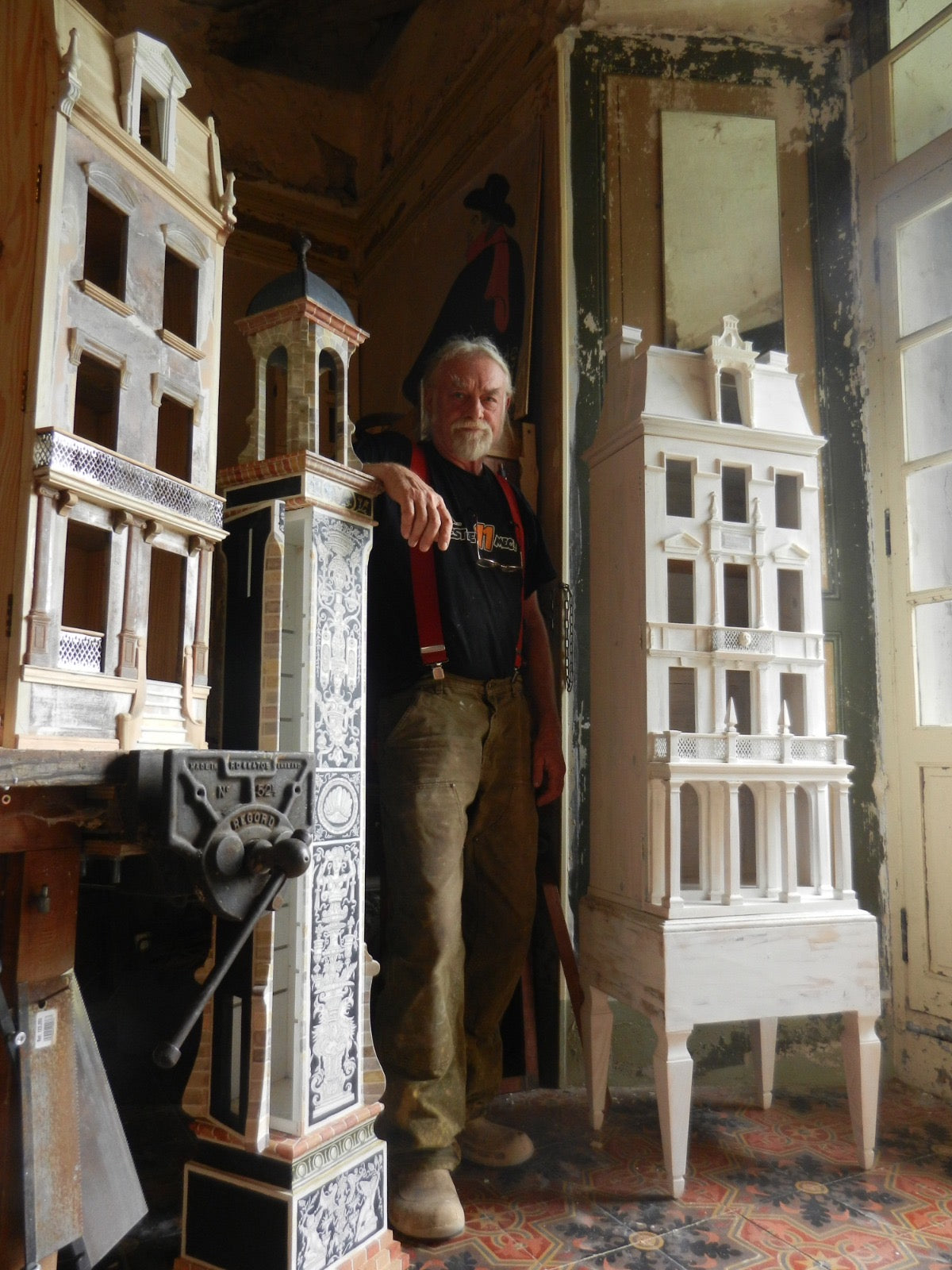 Eric Lansdown surrounded by monumental handmade architectural dollhouses and aviaries in his studio in Gabian, southern France.