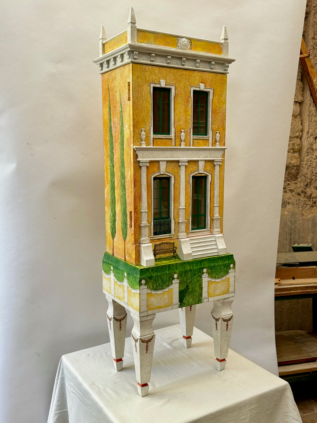 Studio portrait of Piccolo Toscano, a one-of-a-kind Italianate dollhouse and collectible interior sculpture with painted cypress trees and a classical façade.