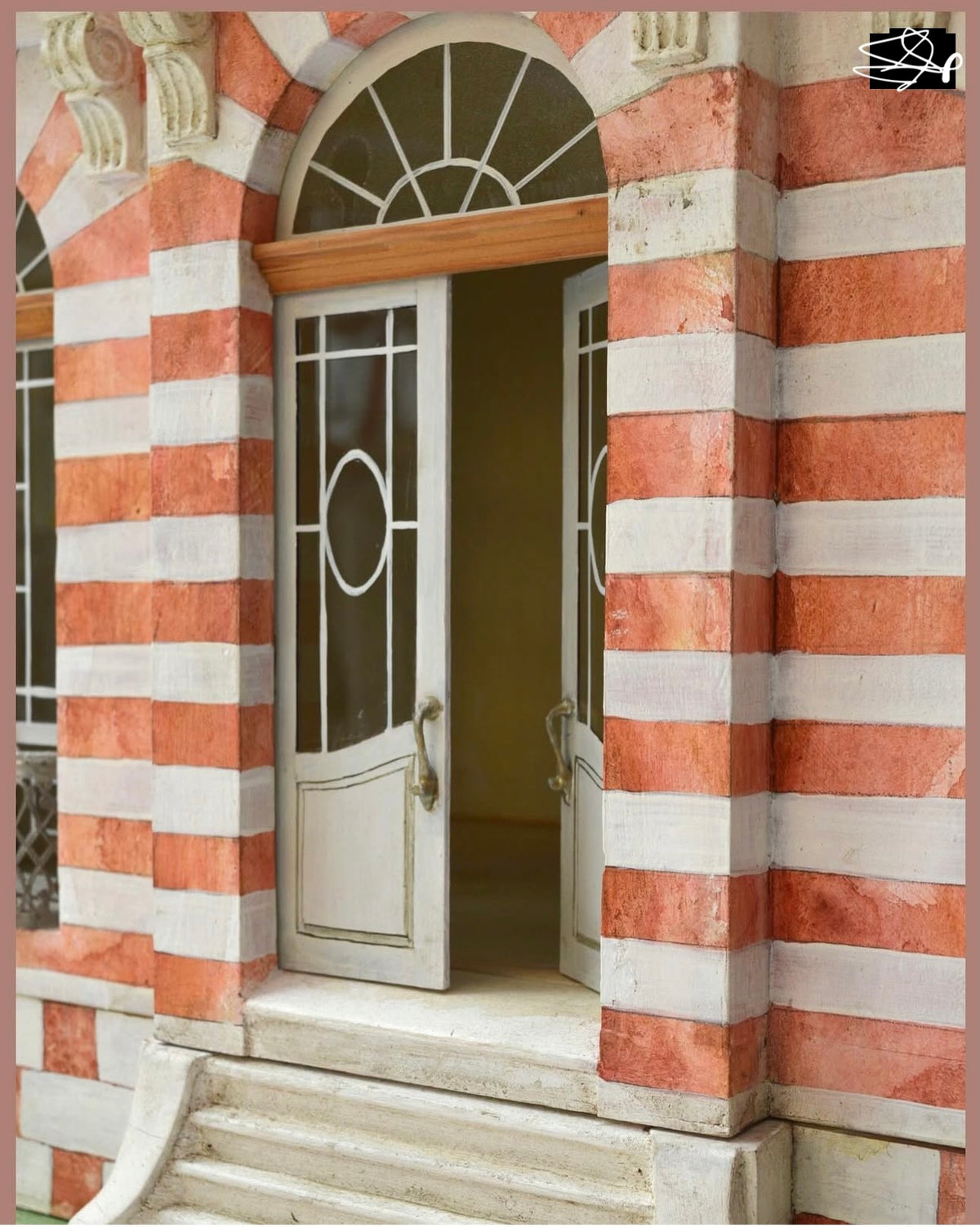 Arched fanlight windows and hand-painted masonry on the entrance of the Red Brick French townhouse dollhouse.