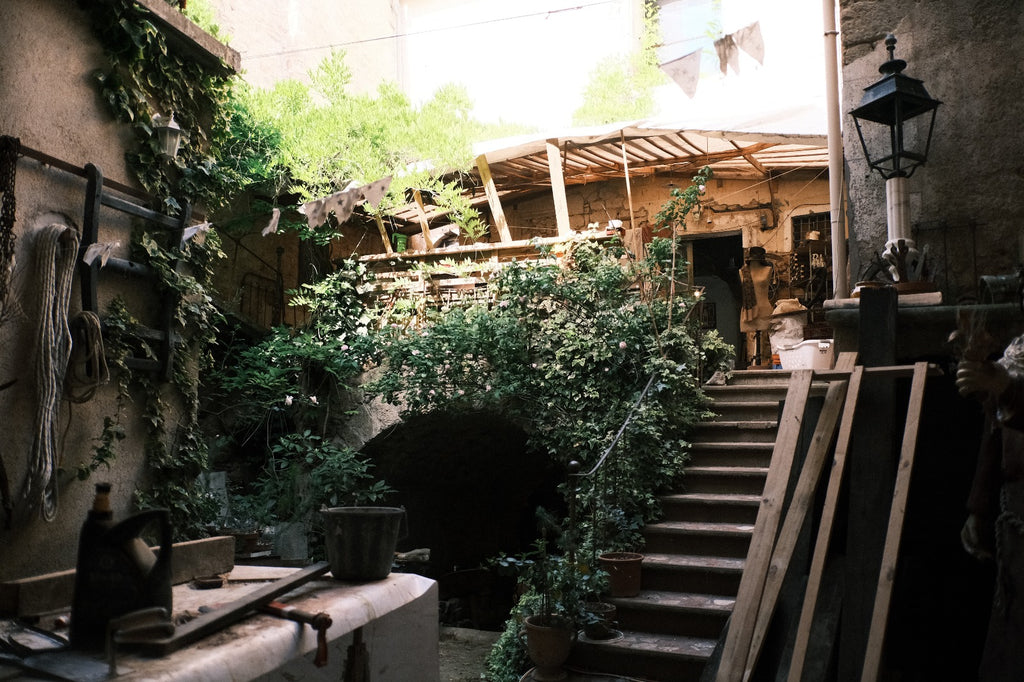 Rustic artisan workshop courtyard at Lansdown Arts in Gabian, France, where Eric Lansdown handcrafts architectural dollhouses