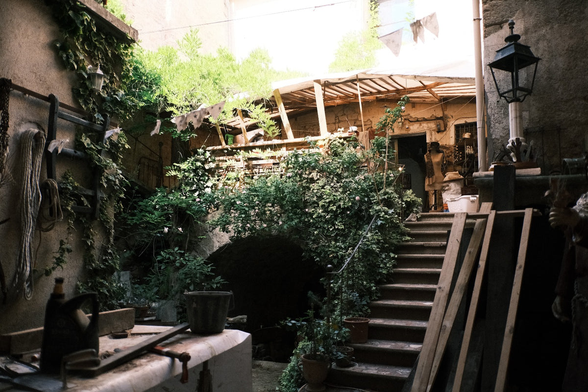 Rustic artisan workshop courtyard at Lansdown Arts in Gabian, France, where Eric Lansdown handcrafts architectural dollhouses