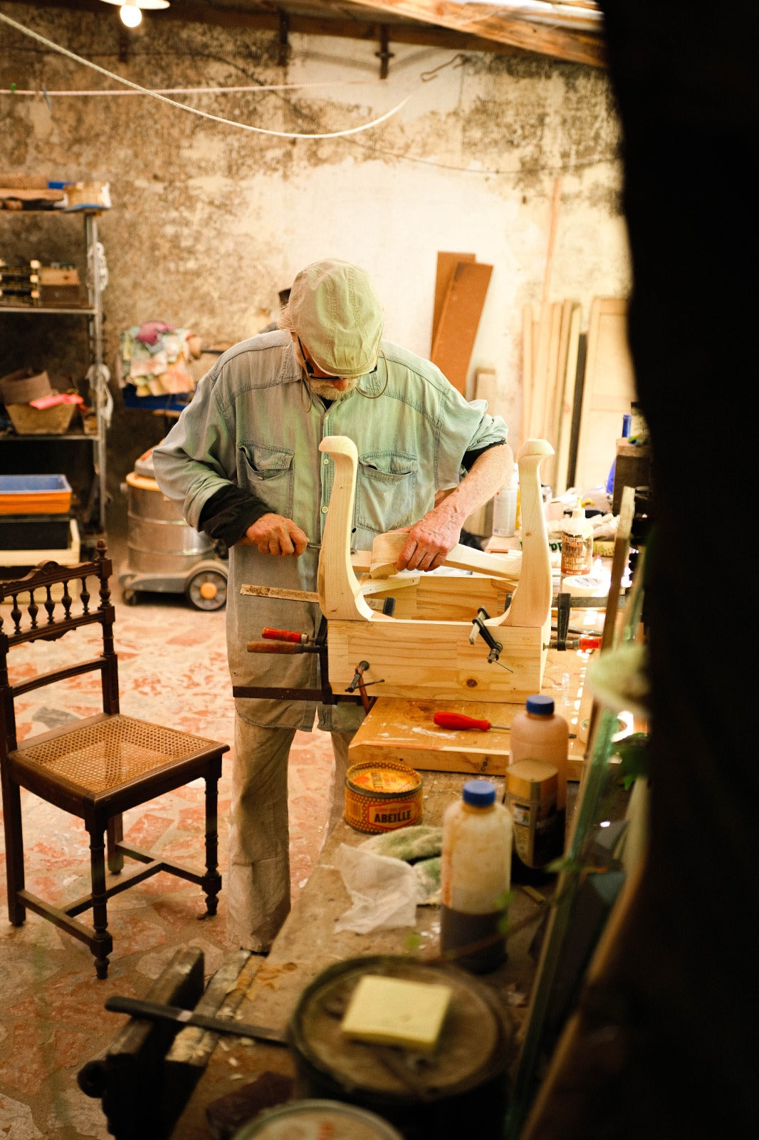 Eric Lansdown handcrafting the sculptural wooden base of Piccolo Toscano in his Gabian workshop, using traditional furniture-making techniques.